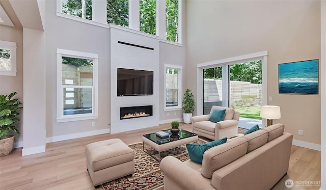 1593 213th Ct NE, Sammamish, WA 98074 - living area with a high ceiling, wood finished floors, and a lit fireplace