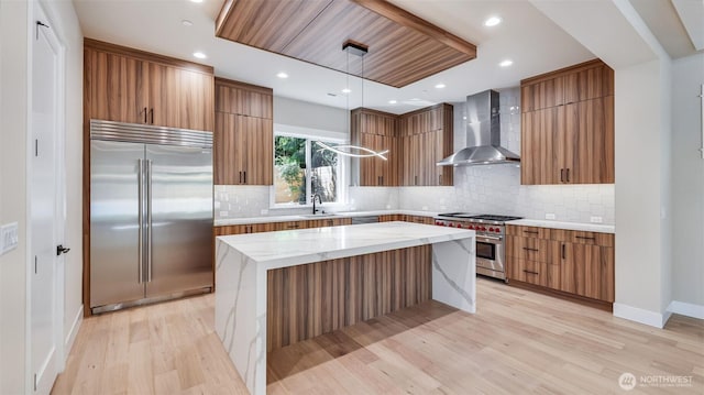 1593 213th Ct NE, Sammamish, WA 98074 - kitchen with high quality appliances, wall chimney exhaust hood, modern cabinets, light wood-type flooring, and brown cabinets