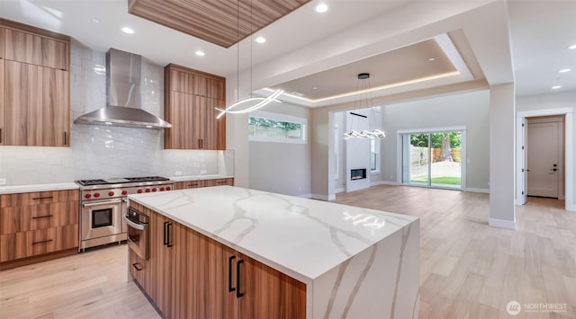 1593 213th Ct NE, Sammamish, WA 98074 - kitchen with wall chimney range hood, modern cabinets, a tray ceiling, stainless steel appliances, and a center island