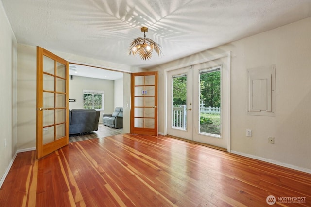 unfurnished room featuring french doors, baseboards, and healthy amount of natural light