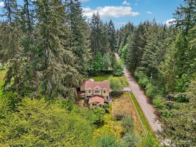 aerial view of property and surrounding area featuring a forest