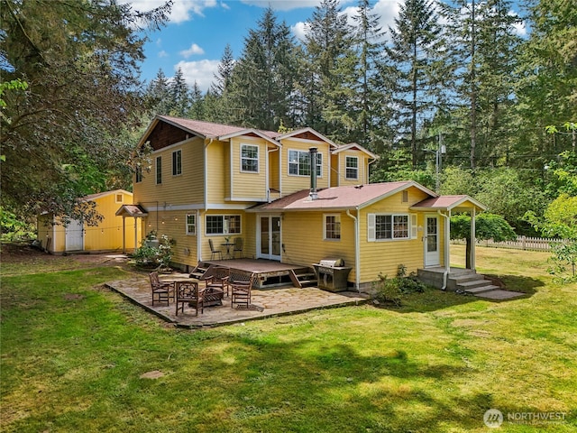 rear view of property with a patio area and view of wooded area