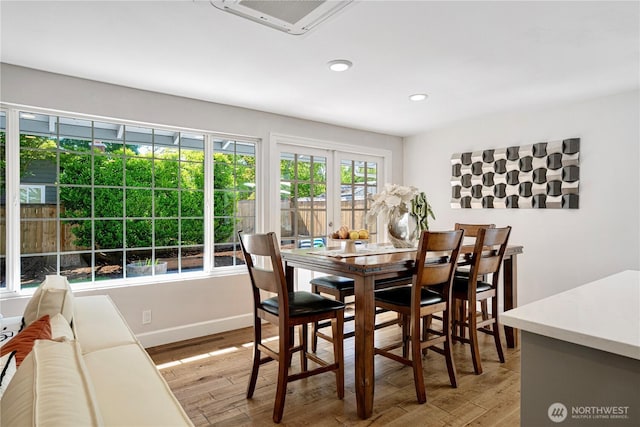 dining room with light wood-style floors, recessed lighting, and baseboards