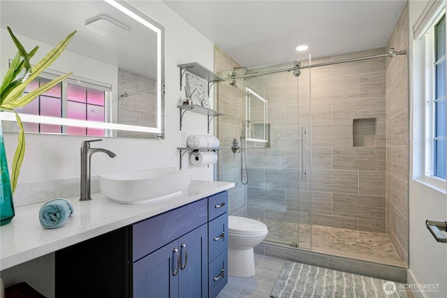 bathroom with a shower stall, vanity, and toilet