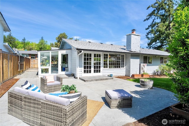 back of house featuring a patio, french doors, a fenced backyard, an outdoor hangout area, and a chimney