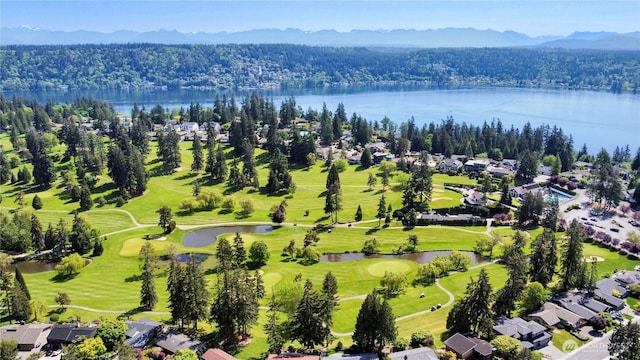 aerial perspective of suburban area with a large body of water, a forest, and a golf course