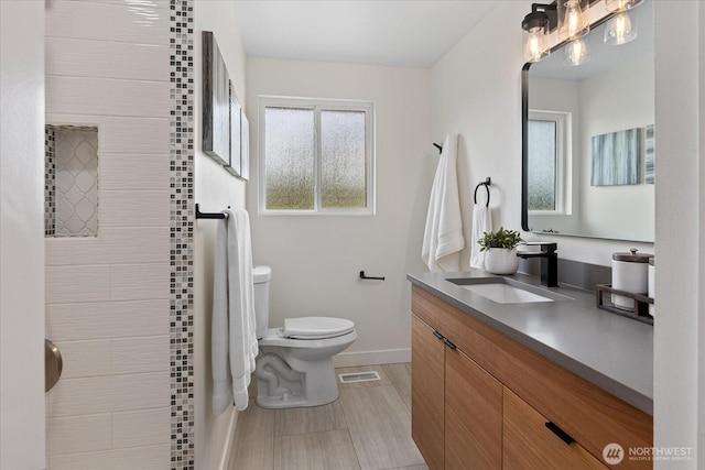 7344 125th Pl SE, Newcastle, WA 98056 - full bathroom with toilet, vanity, a tile shower, and baseboards