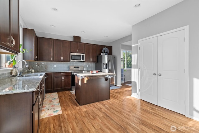 11511 SE 244th, Kent, WA 98030 - kitchen with stainless steel appliances, a sink, dark brown cabinets, light wood-style floors, and recessed lighting