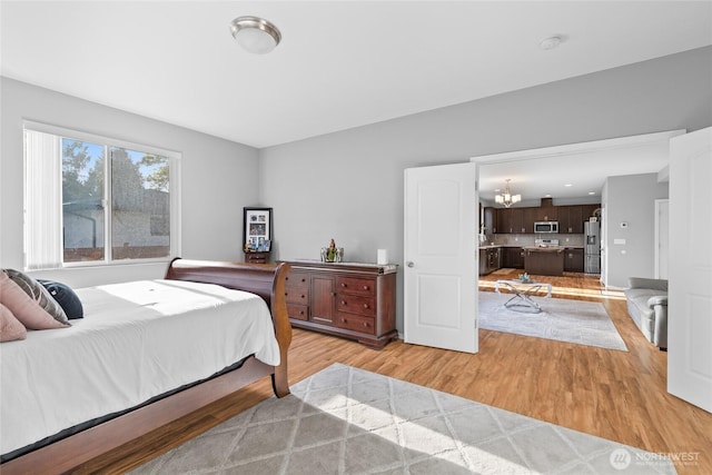 11511 SE 244th, Kent, WA 98030 - bedroom with stainless steel refrigerator with ice dispenser, a chandelier, and light wood-style floors