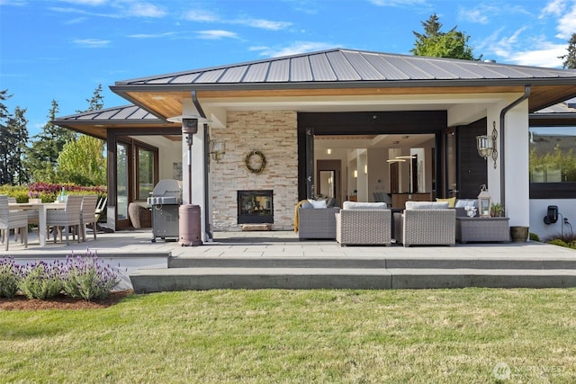 8631 NE 19th Pl, Clyde Hill, WA 98004 - back of house with an outdoor living space with a fireplace, a patio area, metal roof, a standing seam roof, and a yard
