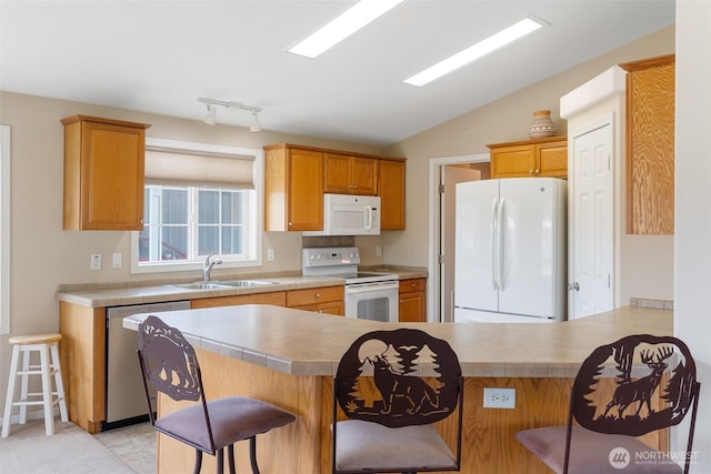 154 Mossyrock Rd W Unit 5, Mossyrock, WA 98564 - kitchen with white appliances, a breakfast bar area, a sink, a peninsula, and lofted ceiling