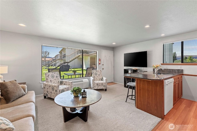 living room with recessed lighting, a textured ceiling, and light wood finished floors