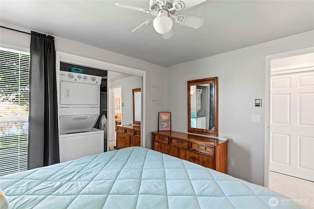 bedroom with stacked washing machine and dryer and a ceiling fan
