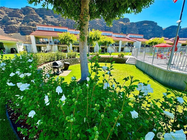 surrounding community with a mountain view and fence