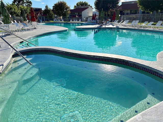 community pool with fence and a patio area