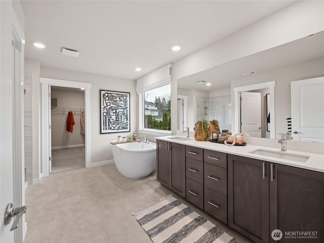8302 114th Ave SE Unit 29, Newcastle, WA 98056 - bathroom with double vanity, a shower stall, a soaking tub, a spacious closet, and recessed lighting
