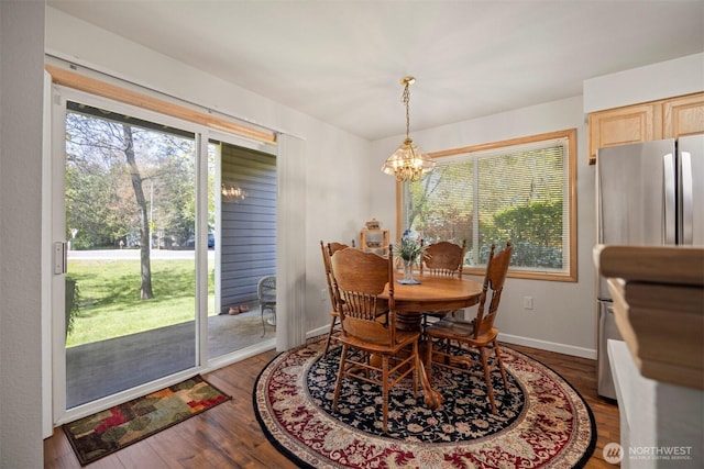 dining room featuring a chandelier, wood finished floors, and baseboards