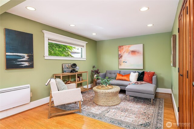 living room with wood finished floors, baseboards, and recessed lighting