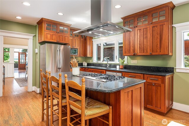 kitchen with island exhaust hood, a sink, recessed lighting, healthy amount of natural light, and light wood-style flooring