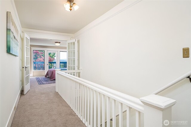 hall with light colored carpet and french doors