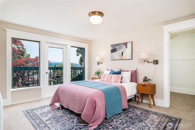 carpeted bedroom with access to exterior and baseboards