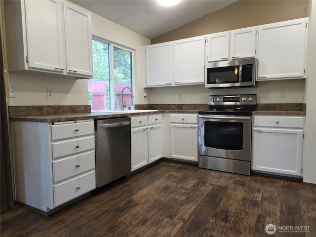 7509 43rd Ave SE, Lacey, WA 98503 - kitchen with stainless steel appliances, vaulted ceiling, dark countertops, a sink, and white cabinets