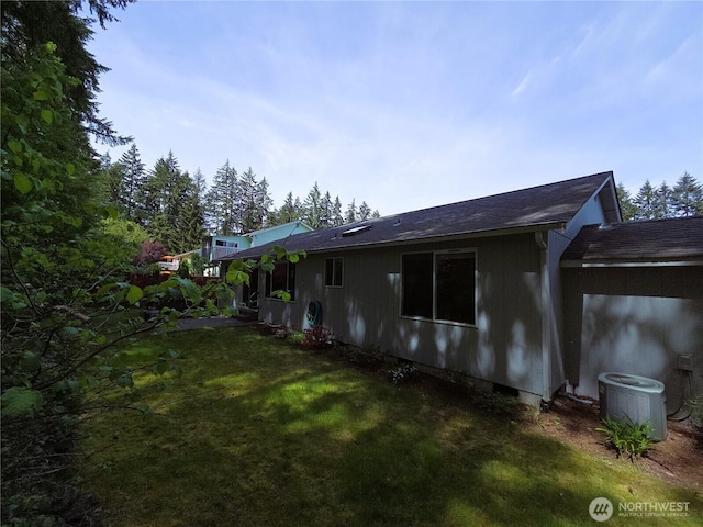 7509 43rd Ave SE, Lacey, WA 98503 - view of property exterior featuring central AC unit, a lawn, and a shingled roof