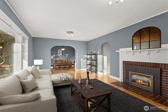 1250 N Broadway St, Aberdeen, WA 98520 - living room with arched walkways, wood finished floors, a fireplace, and ornamental molding