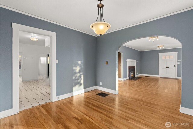 1250 N Broadway St, Aberdeen, WA 98520 - unfurnished room featuring arched walkways, crown molding, wood finished floors, and a fireplace with flush hearth