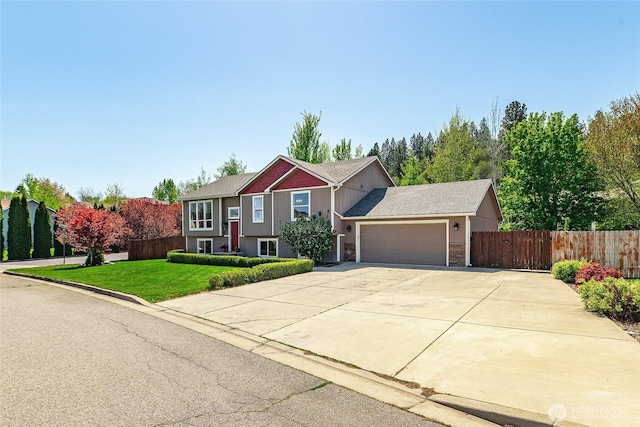 raised ranch with an attached garage and driveway