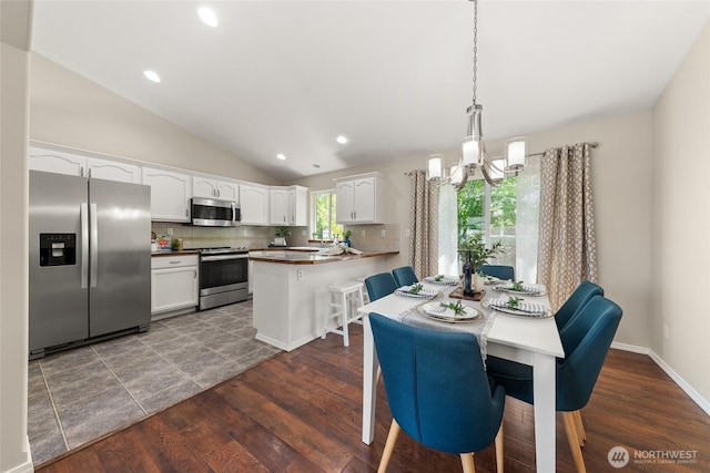 dining space featuring a chandelier, lofted ceiling, dark wood-style floors, and recessed lighting