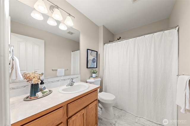 bathroom with marble finish flooring, vanity, and toilet