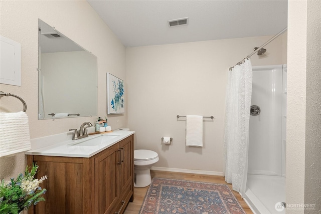 bathroom with wood finished floors, curtained shower, vanity, and toilet