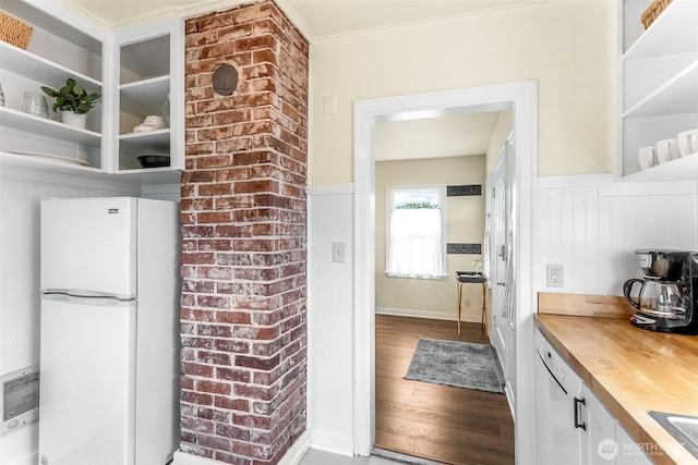 kitchen with freestanding refrigerator, wooden counters, wood finished floors, open shelves, and ornamental molding