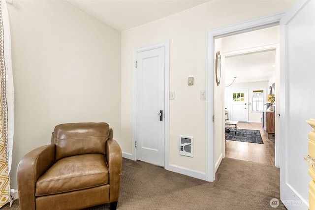 living area featuring carpet flooring, heating unit, and baseboards