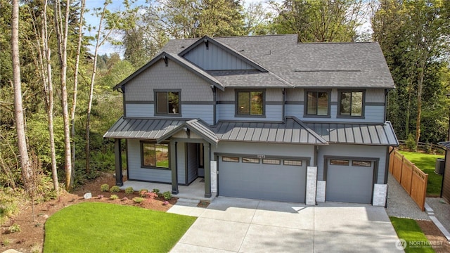 view of front facade with a standing seam roof, a shingled roof, concrete driveway, an attached garage, and a porch