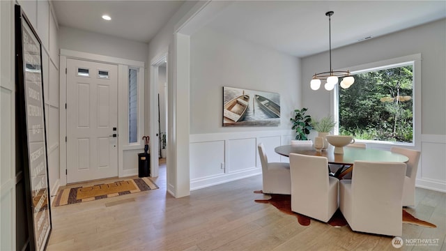 entrance foyer with light wood-style floors, a wainscoted wall, a decorative wall, a chandelier, and recessed lighting