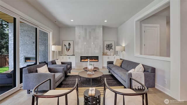 living area with a fireplace, light wood-style floors, recessed lighting, and baseboards