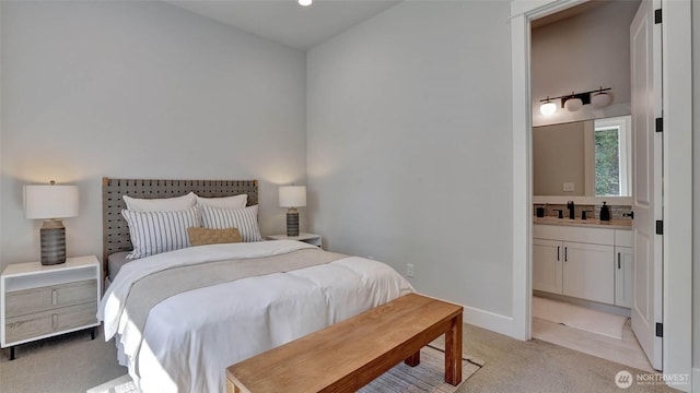 bedroom with light colored carpet, ensuite bath, a sink, recessed lighting, and baseboards