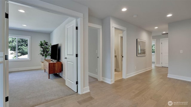 corridor featuring light wood-type flooring, baseboards, and recessed lighting