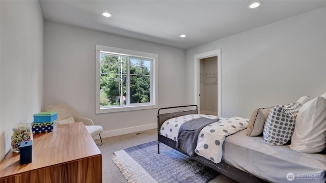 carpeted bedroom with baseboards, recessed lighting, and a walk in closet