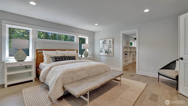bedroom featuring light wood finished floors, recessed lighting, and baseboards