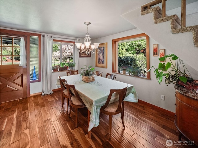 dining area featuring a chandelier, wood finished floors, and baseboards