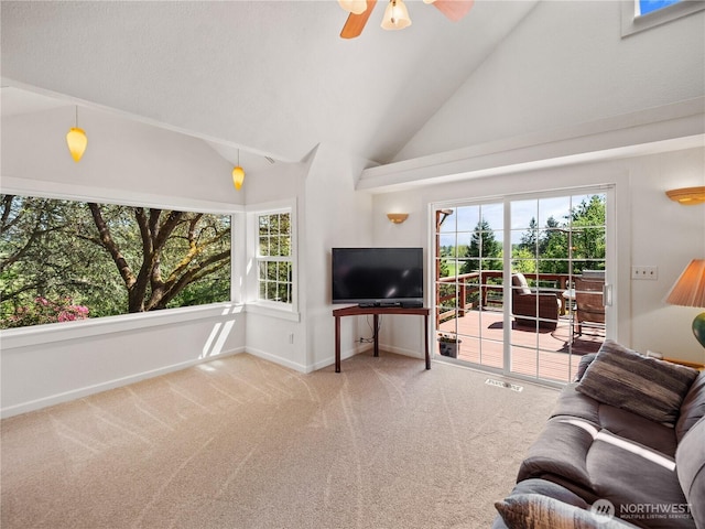 living room featuring carpet flooring, healthy amount of natural light, vaulted ceiling, ceiling fan, and baseboards