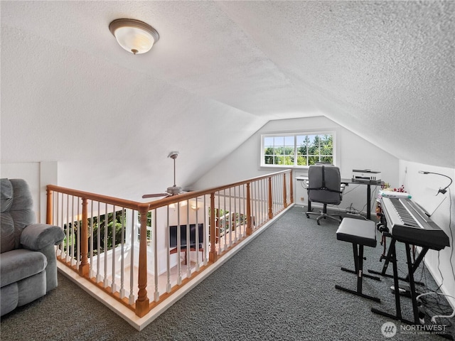 carpeted office with a textured ceiling, vaulted ceiling, and a ceiling fan