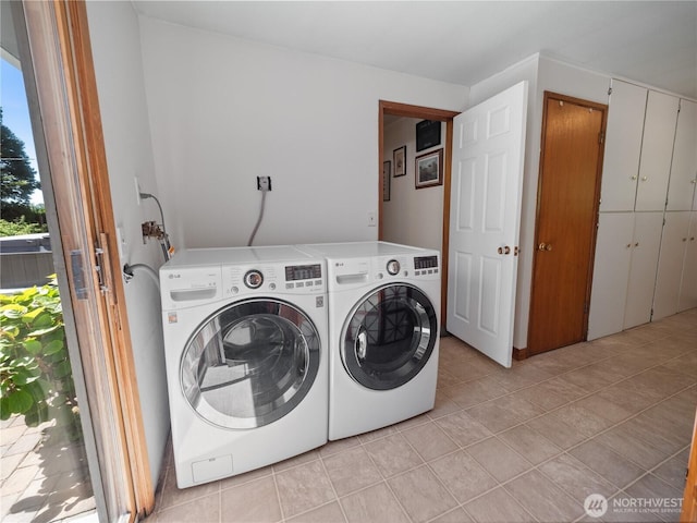 clothes washing area featuring washer and dryer and light tile patterned flooring