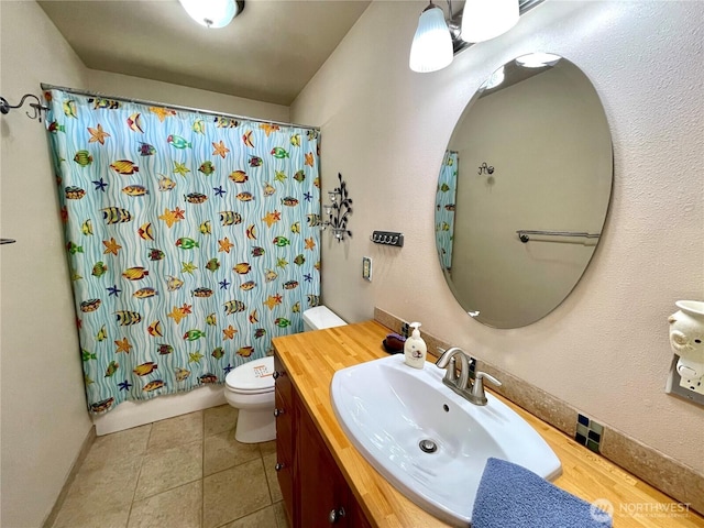 full bath with toilet, vanity, shower / bath combo with shower curtain, and baseboards