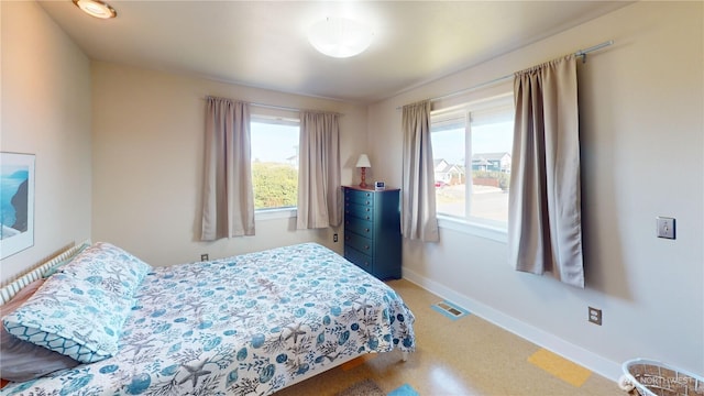bedroom featuring baseboards and light floors