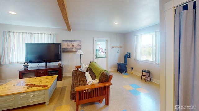 living area with a wood stove, baseboards, recessed lighting, and beam ceiling