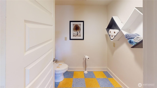 bathroom with tile patterned floors, toilet, and baseboards